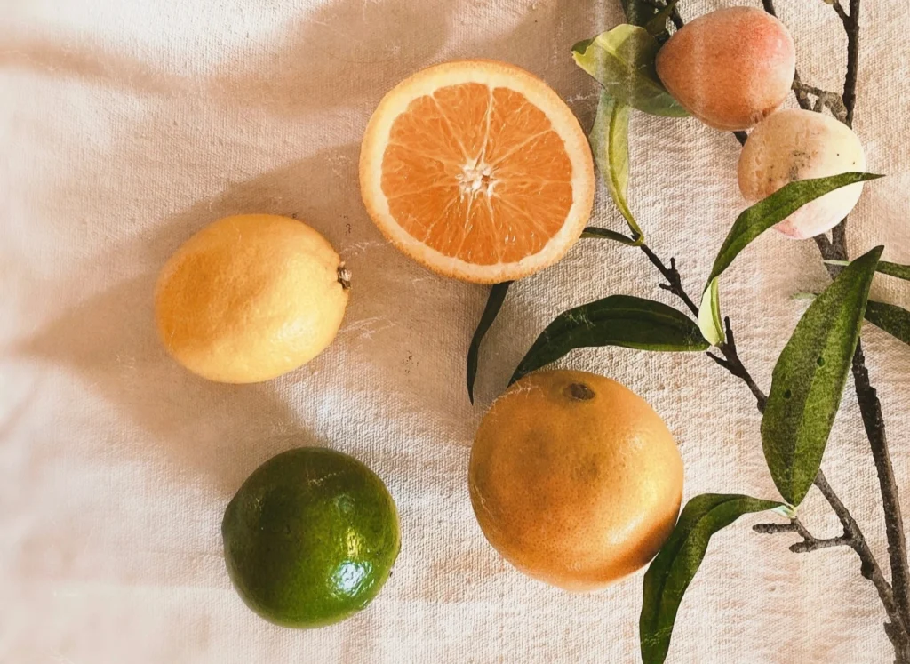 Agrumes variés sur fond en tissu beige – citron, orange, lime et fruits exotiques