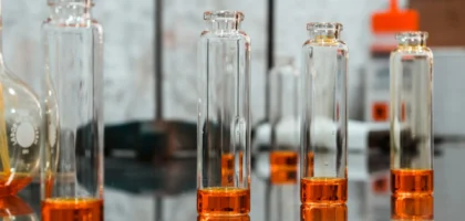 Flacons de parfum dans un laboratoire illustrant la création des notes olfactives de tête, cœur et fond.