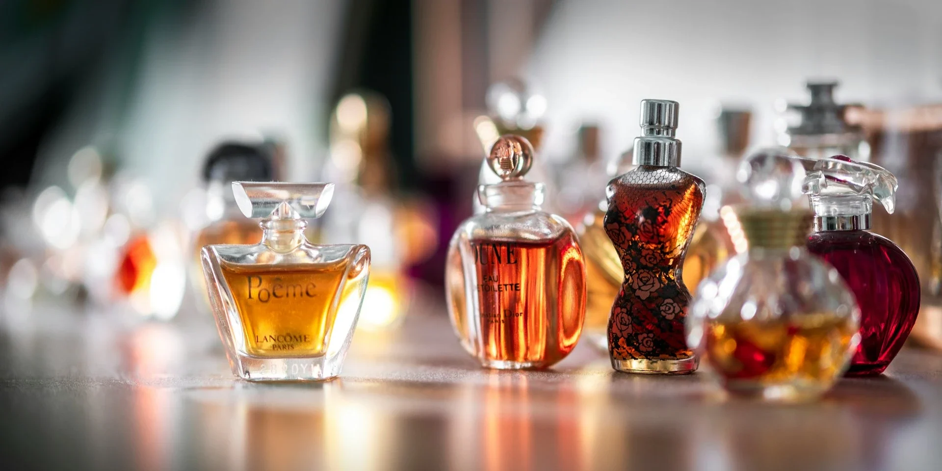 Collection de flacons de parfum élégants, aux formes variées et au liquide ambré, reflétant la richesse des fragrances artisanales.