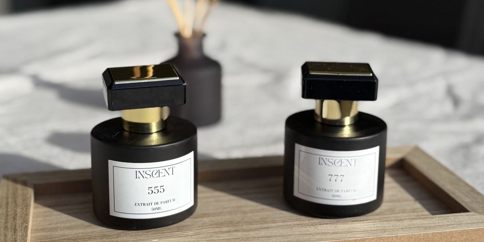 Flacons des parfums INSCENT 555 et INSCENT 777 posés sur un plateau, extraits de parfum artisanaux français.